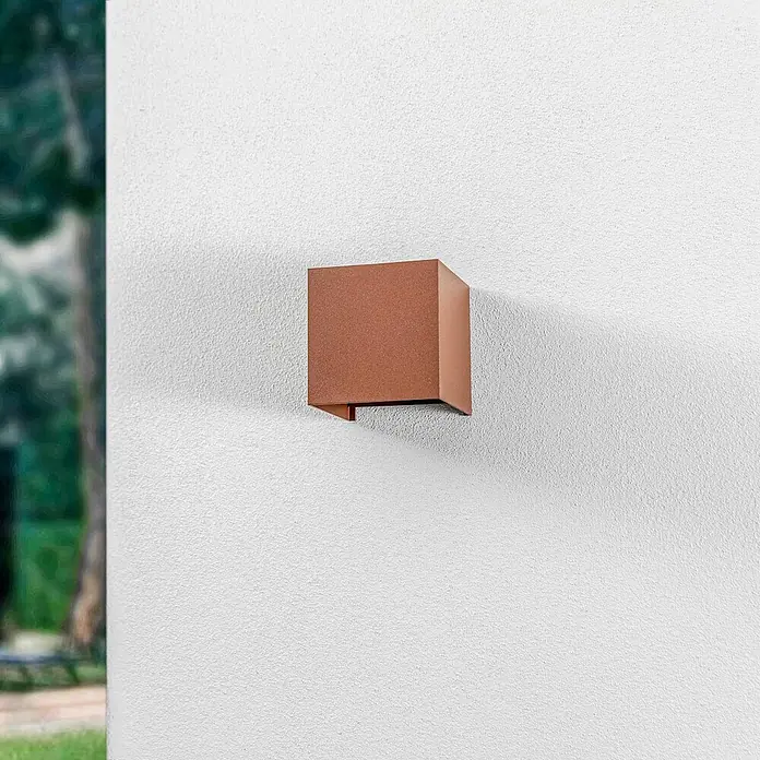 Lindby Außenwandleuchte Nivar - braun / rost, IP54 - Kupferfarbene quadratische Wandleuchte an einer strukturierten weißen Außenwand montiert.