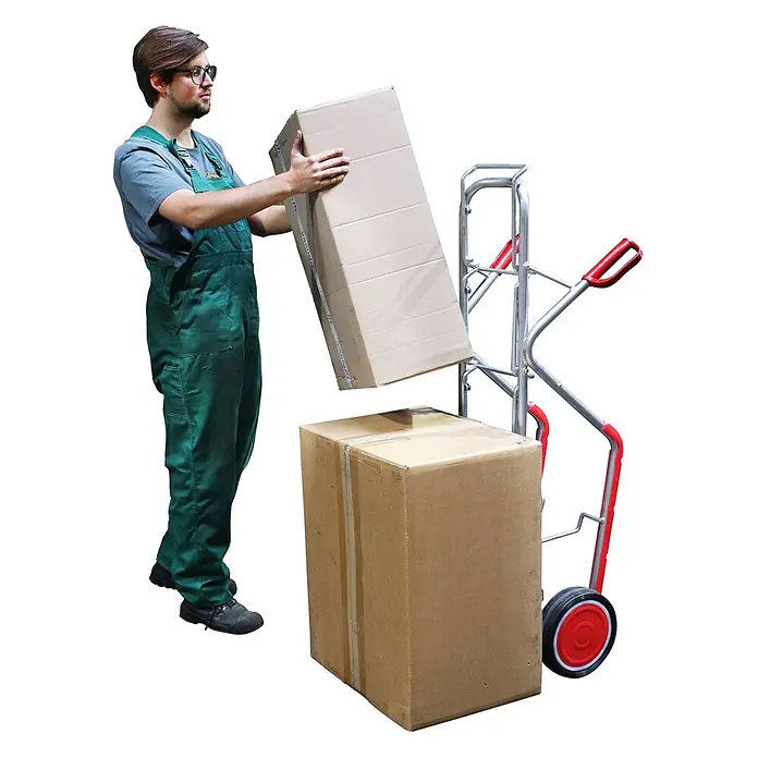 Variofit Sackkarre VARIOfit Wasserflaschenkarre Aluminium mit Vollgummibereifung - Aluminium, Traglast: 200 kg - Eine Person in grüner Arbeitskleidung lädt einen Karton auf eine silberne Sackkarre mit roten Griffen und Rädern, daneben ein weiterer Karton.