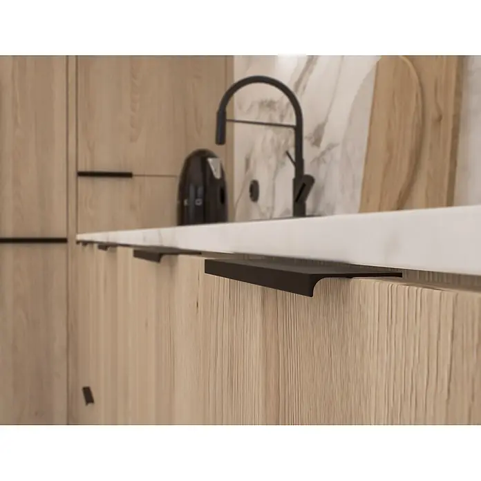 Cordia Möbelgriff 20 cm - Lochabstand: 160 mm, Aluminium, Schwarz - Schwarze Griffprofile in hellen Holzküchenschränken, ergänzt durch eine weiße Arbeitsplatte und schwarzen Wasserhahn.