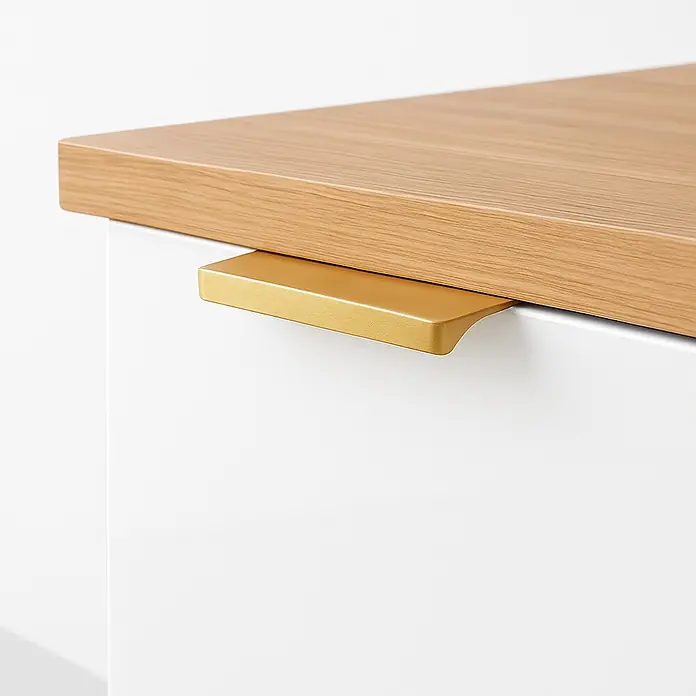 Cordia Möbelgriff 5 cm - Lochabstand: 24 mm, Aluminium, Gold - Goldfarbener Griffleiste an einer weißen Schublade unter einer hellen Holzplatte.