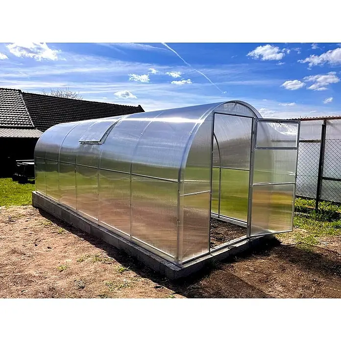 Garten Dream Gewächshaus Mini, 4mm Polycarbonat - Außenmaß inkl. Dachüberstand (B x T): 200 x 600 cm, Material Seitenwand: Kunststoff, 4 mm, Silber - Großes bogenförmiges Polycarbonat-Gewächshaus mit offener Tür und Dachluke, auf Betonfundament im Garten, bereit zur Bepflanzung.