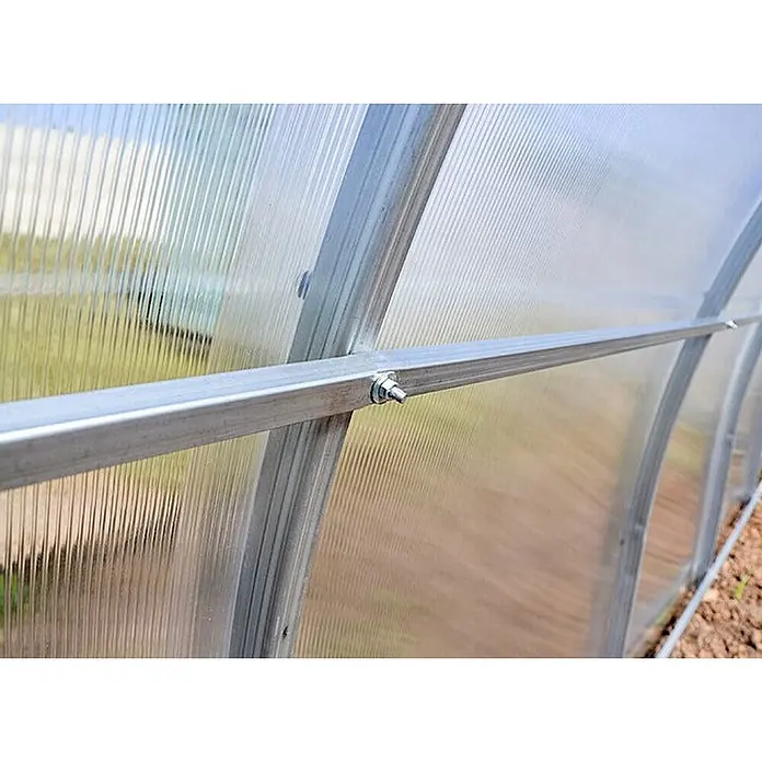 Garten Dream Gewächshaus Sofia, 4mm Polycarbonat - Außenmaß inkl. Dachüberstand (B x T): 350 x 600 cm, Material Seitenwand: Kunststoff, 4 mm, Silber - Detail einer Gewächshausstruktur mit lichtdurchlässigen Wellpolycarbonatplatten und einem silbernen Metallrahmen, mit Bolzen befestigt.