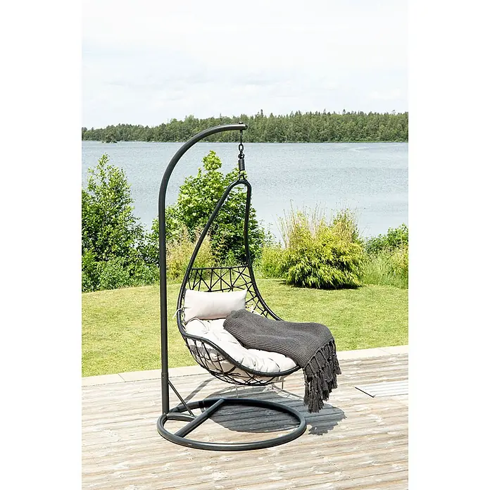 Ebuy24 Hängesessel Vide - Polyester, Schwarz - Schwarzer Hänge-Eiersessel aus Metall mit hellen Kissen und dunkler Decke, auf einer Terrasse am See.
