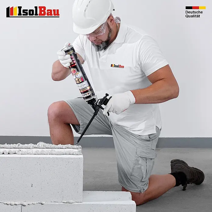IsolBau Klebeschaum PU Mauermörtel - 3 x 750ml - 750 ml - Ein Mann kniet und trägt IsolBau Klebeschaum aus einer Dose mit einer Pistole auf weiße Bausteine auf.