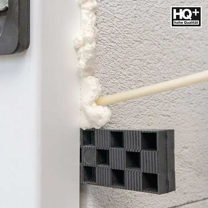 IsolBau Adapterschaum Montageschaum mit Aussprührohr 1 x 750 ml - 750 ml - Weißer Bauschaum wird mit Düse in Spalt neben Rahmen gespritzt. Ein schwarzer Kunststoffstützblock ist darunter.