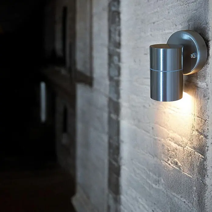 DAPO Außenwandleuchte Bornholm, Silber, Edelstahl, GU10, IP44 -  - Zylindrische Wandleuchte aus gebürstetem Metall, spendet warmes Licht an einer strukturierten Wand.