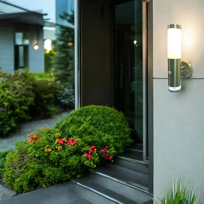 DAPO Außenwandleuchte Lisa, mit LED-Kranz, Edelstahl, E27, IP44 -  - Gebürstete Metall-Außenwandleuchte mit weißem zylindrischem Diffusor und Bewegungssensor, der einen Eingang beleuchtet.