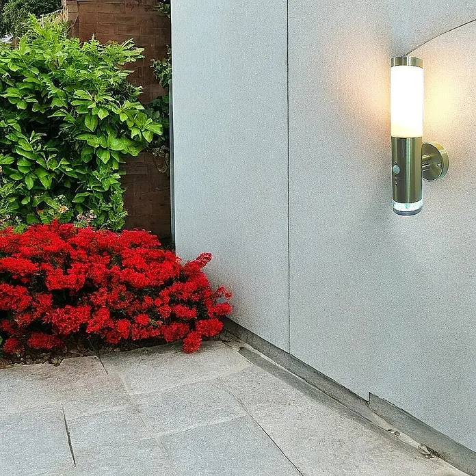 DAPO Außenwandleuchte Lisa, mit LED-Kranz, Edelstahl, E27, IP44 -  - Zylindrische Außenwandleuchte aus gebürstetem Metall mit Bewegungssensor, beleuchtet einen Terrassenbereich.