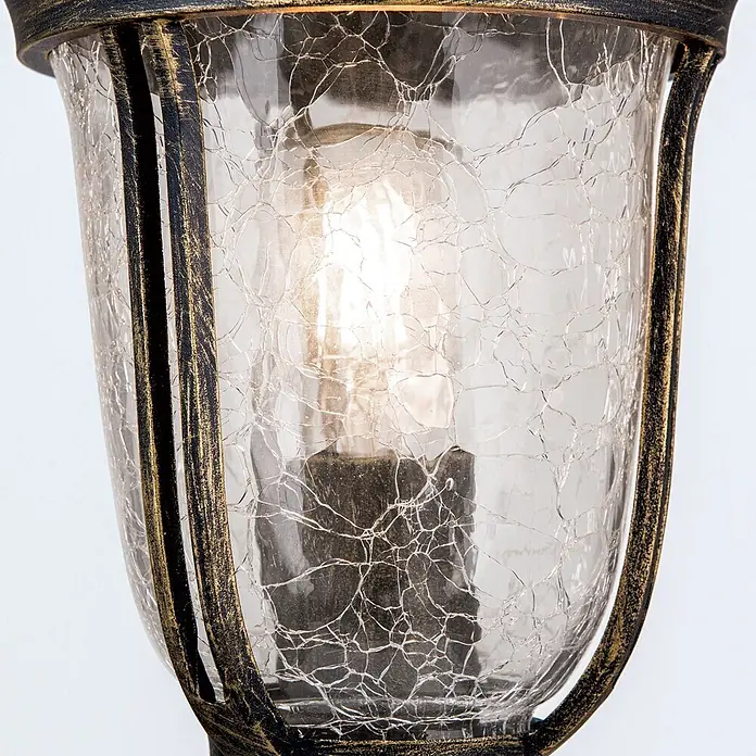 Orion Leuchten Außensockelleuchte - Ohne Leuchtmittel - Nahaufnahme einer leuchtenden Lampe mit Craqueléglas und antikem schwarz-goldenem Metallrahmen.