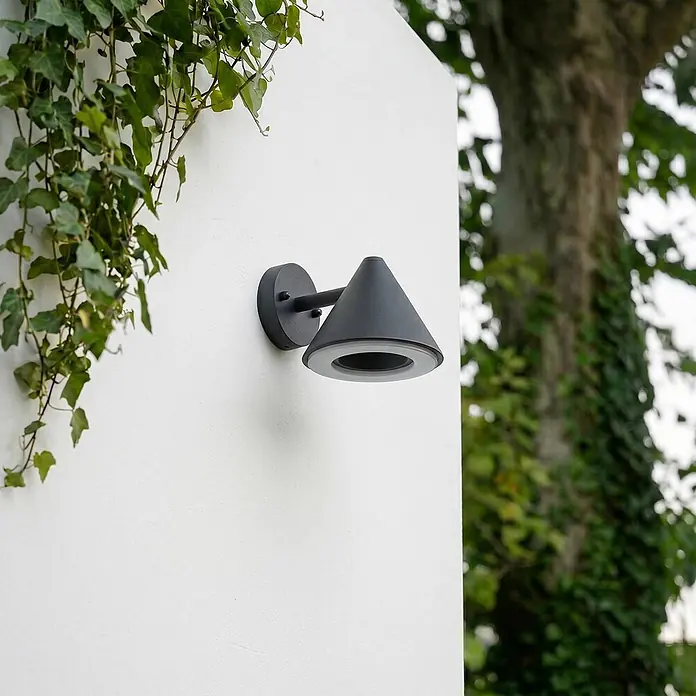 Lindby Außenwandleuchte Soran - schwarz, schwarz, IP44 - Dunkelgraue konische Außenwandleuchte, an einer weißen Wand montiert, mit sichtbarem Lichtring.
