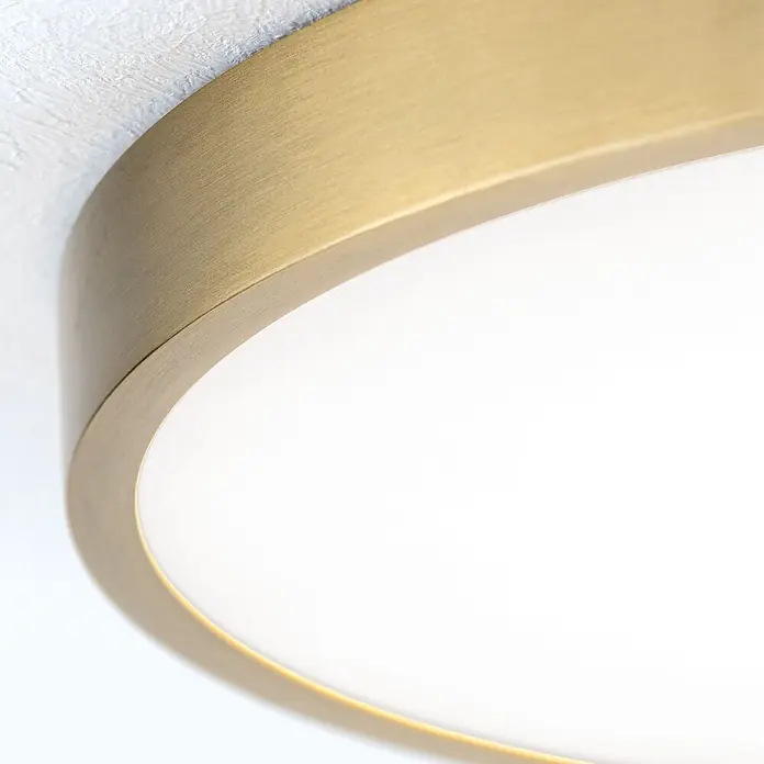 Orion Leuchten LED-Panel rund -  - Nahaufnahme einer runden Deckenleuchte mit gebürstetem Messingrand und weißem, beleuchtetem Diffusor.