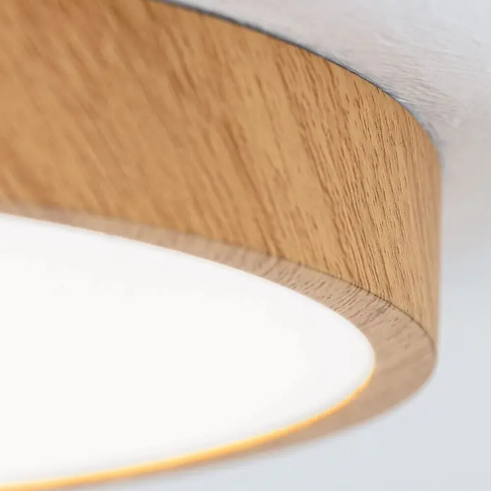 Orion Leuchten LED-Panel rund -  - Nahaufnahme einer runden Deckenleuchte mit hellem Holzrahmen und weißem, beleuchtetem Diffusor.