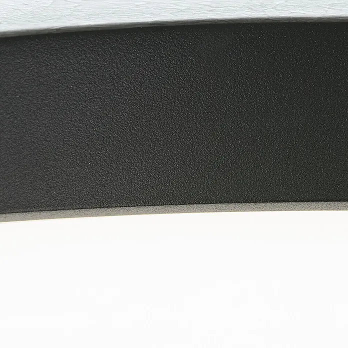 Orion Leuchten LED-Panel rund -  - Nahaufnahme einer schwarzen, strukturierten Oberfläche mit hellem oberen Rand.