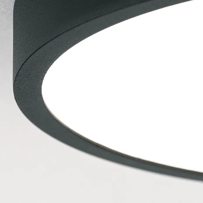 Orion Leuchten LED-Panel rund -  - Nahaufnahme einer runden schwarzen, texturierten LED-Leuchte, die helles weißes Licht abgibt.