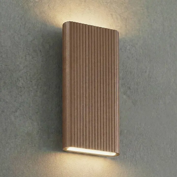 Lucande Außenwandleuchte Raija - braun / rost, IP54 - Braune geriffelte Wandleuchte, die eine strukturierte Wand nach oben und unten beleuchtet.