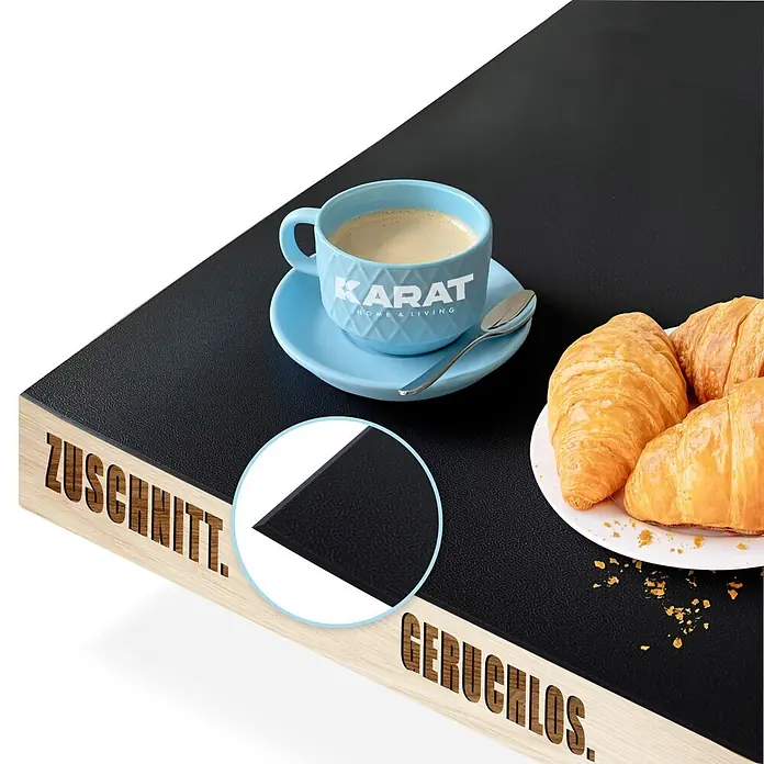Karat Tischbelag Schräge Kante - 80 x 80 cm, Schwarz, Kunststoff - Schwarze, strukturierte Matte auf Holz, mit Kaffee. Betont 'Zuschnitt' und 'Geruchlos', inklusive Detailansicht der Textur.