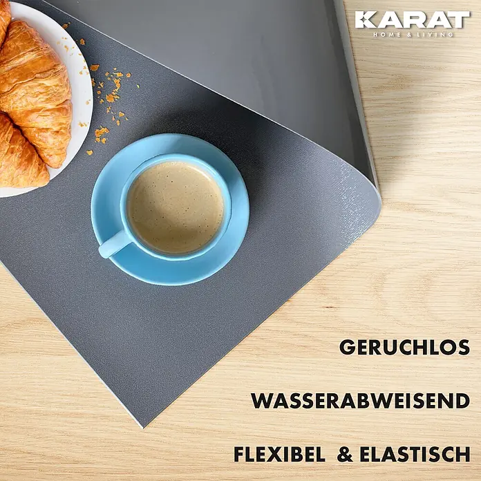 Karat Tischbelag Schräge Kante - 140 x 80 cm, Dunkelgrau, Kunststoff - Dunkelgraue flexible, wasserabweisende Matte mit strukturierter und glatter Seite, mit Kaffee und Croissants gezeigt.