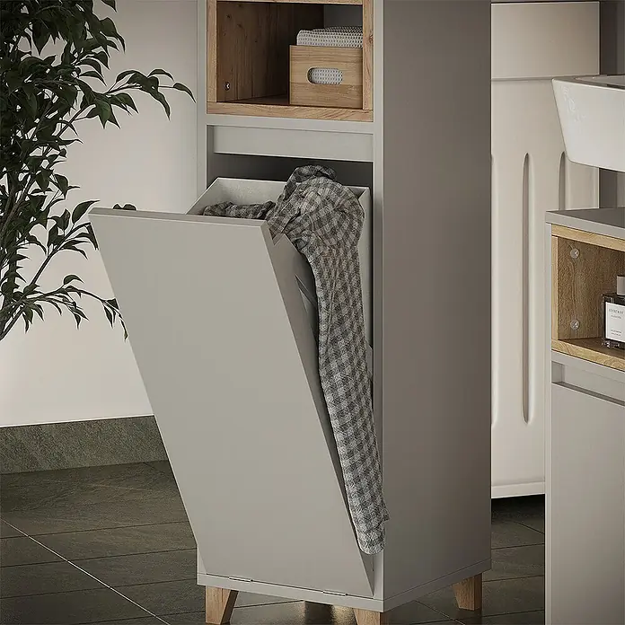 Vicco Badmöbel-Set Elnor Greige 3 Teile mit Midischrank - Greige, Matt - Hellgrauer Schrank mit Holzbeinen und offenem Kippwäschekorb mit kariertem Hemd, in modernem Raumambiente.