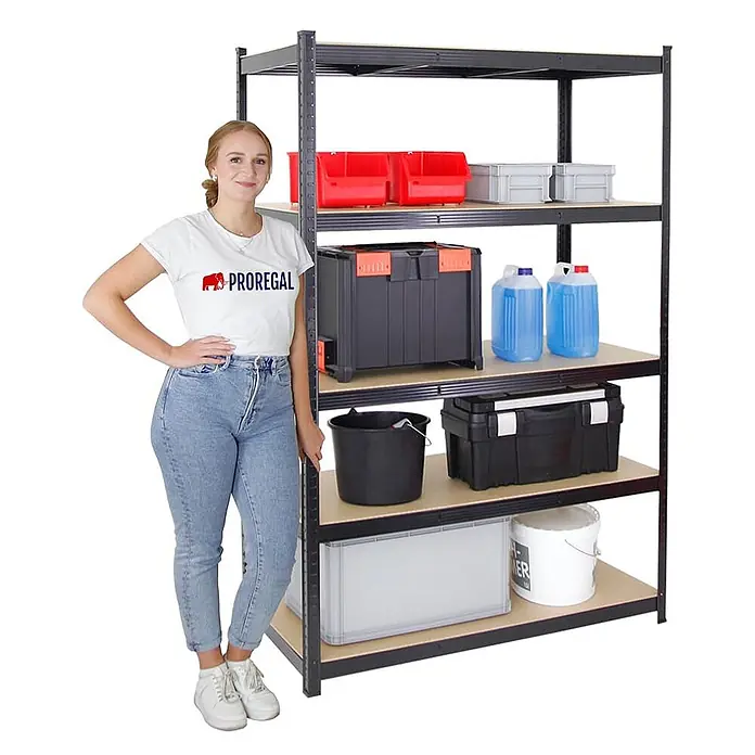 Proregal Schwerlastregal Mega Deal TAURUS 2 Stück - Traglast pro Boden: 175 kg, Anzahl Böden: 5 Stk., Stecken, Schwarz - Frau neben einem schwarzen Metallregal mit Holzböden, gefüllt mit Lagerbehältern, Werkzeugkisten und Containern.