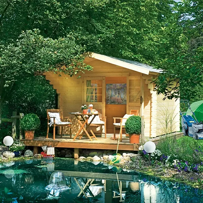 Kiehnholz Gartenhaus Helsinki - Außenmaß inkl. Dachüberstand (B x T): 340 x 443 cm, Holz, Natur - Ein gemütliches Gartenhaus mit Terrasse am Teich, umgeben von üppigem Grün, lädt zum Entspannen ein. Die Holzoptik fügt sich nahtlos in die Natur ein.