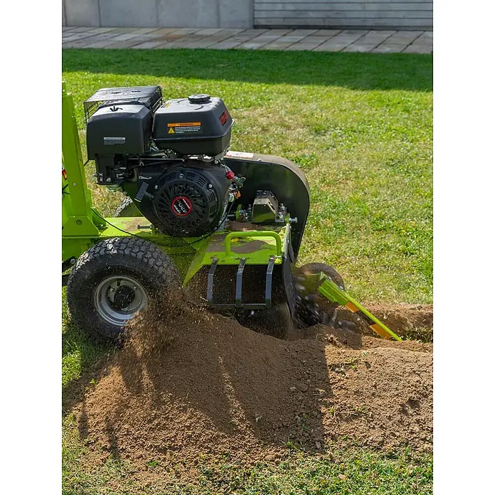 Zipper Grabenfräse ZI-GRF1000 - 9 kW, Tankvolumen: 6,5 l, Seilzug - Grüne und schwarze Grabenfräse beim Graben eines Grabens im Grasboden, die braune Erde aufwirft.