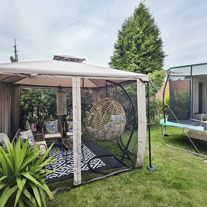 Outsunny Standard-Pavillon - Farbe Gestell: Grau, Metall - Beiges Outdoor-Pavillon mit Netzgewebe, das Gartenmöbel und einen Rattan-Eiersessel umschließt.