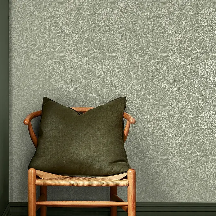 William Morris At Home Vliestapete Vliestapete Ringelblume, faserig - Salbeigrün, Floral, 10 x 0,52 m - Salbeigrüne Tapete mit floralem Muster, Stuhl und dunklem Kissen zur Größenanzeige.