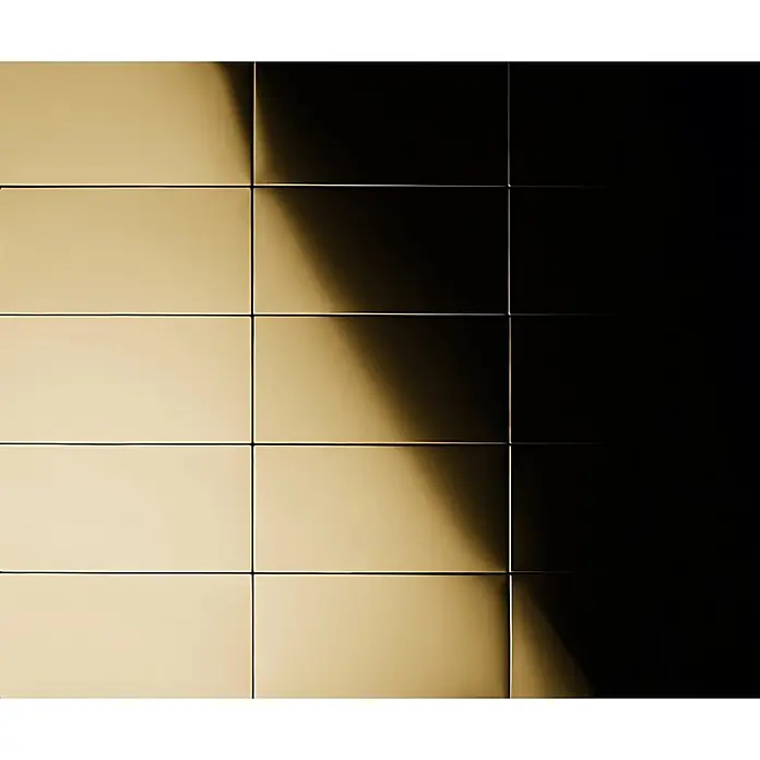 ALLOY Mosaikfliese Mosaik Fliese massiv Titan hochglänzend gold 1,6mm stark Subway-Ti-GM - 76 x 152 mm, Gold, Hochglänzend - Goldfarbene rechteckige Metallpaneele mit reflektierender Oberfläche, von starkem diagonalem Licht beleuchtet, das einen Verlauf erzeugt.