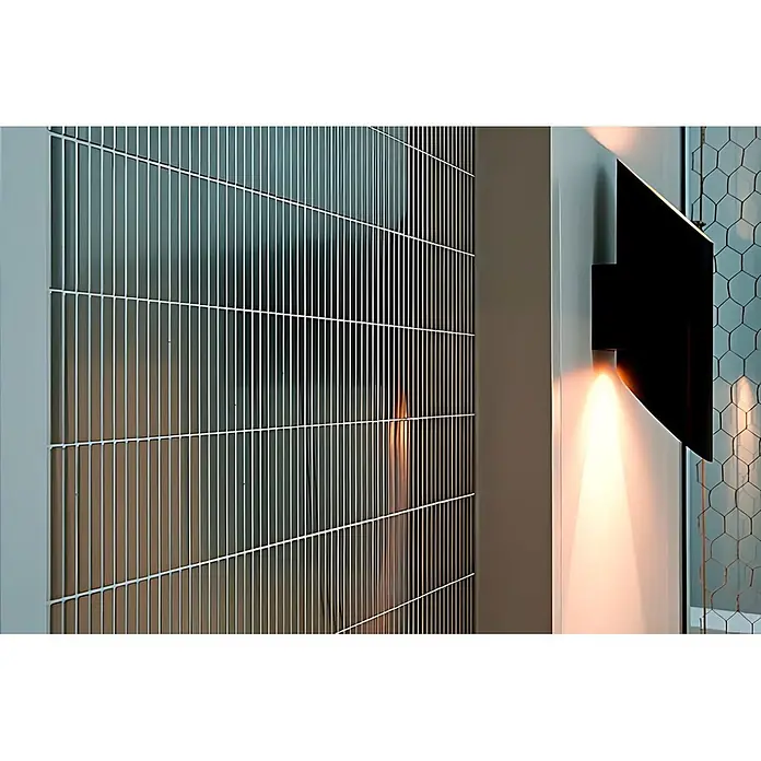 ALLOY Mosaikfliese Mosaik Fliese massiv Metall Edelstahl hochglanz grau 1,6mm Linear-S-S-M - 316 x 297 mm, Grau, Silber, Hochglänzend - Moderner metallischer Gitter-Raumteiler oder Dekorsichtschutz, neben einer Wandleuchte mit warmem, nach oben gerichtetem Licht.