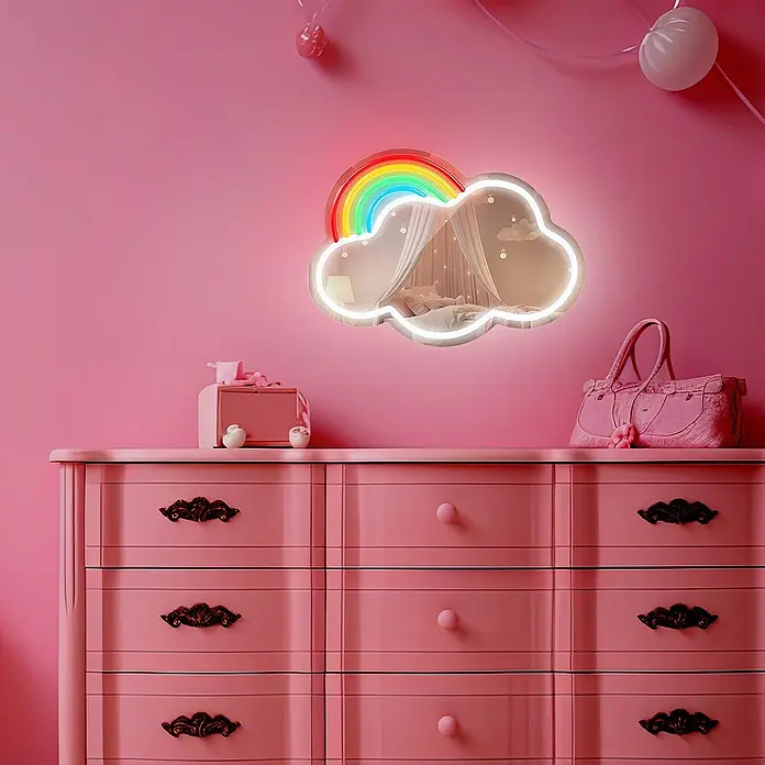Lámpara decorativa Mirror LED Cloud - 4 W, 32 x 26 cm, Interruptor, Espejo Nube - Espejo LED en forma de nube con arcoíris, que refleja una cama, colgado sobre una cómoda rosa.