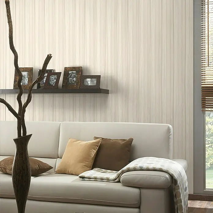 Paneel Buche Donau - 2.600 x 202 x 10 mm - Elegantes Wohnzimmer mit beigem Sofa, Zierkissen, Holzvase und einer schwebenden Ablage mit Bilderrahmen vor einer hellen Paneelwand.