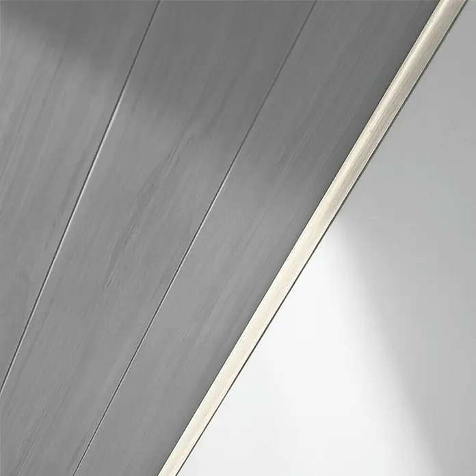 LOGOCLIC Abdeckleiste Buche Donau - 260 cm x 25 mm x 6 mm - Nahaufnahme einer grauen Holzpaneeldecke mit einer eingelassenen LED-Leiste, die sanftes Licht spendet.\n