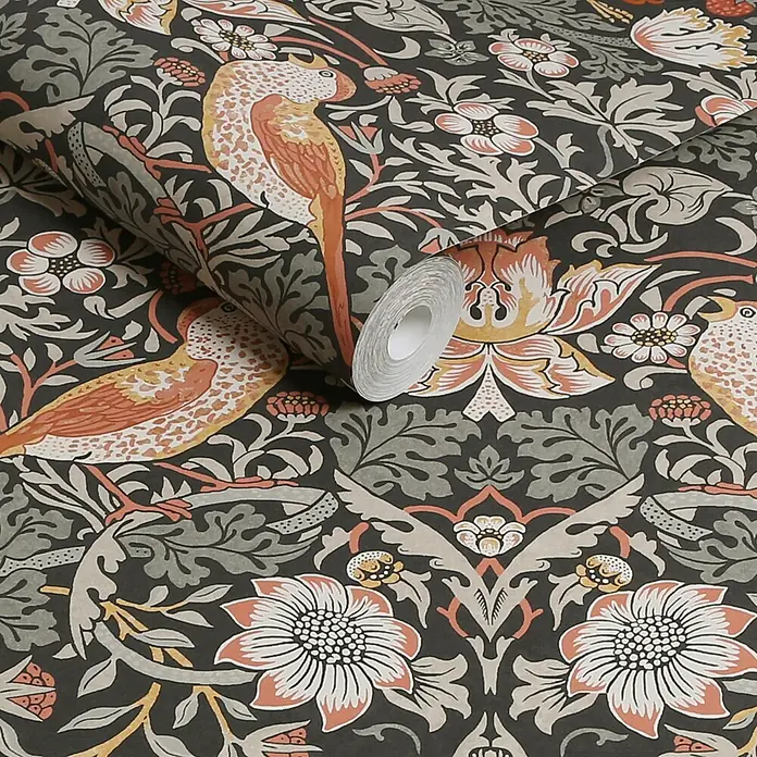 William Morris At Home Vliestapete Erdbeerdieb - Grau, Floral, 1.000 x 52 cm - Tapetenrolle mit einem kunstvollen Muster aus orangefarbenen und gelben Vögeln und floralen Motiven auf dunklem Hintergrund.