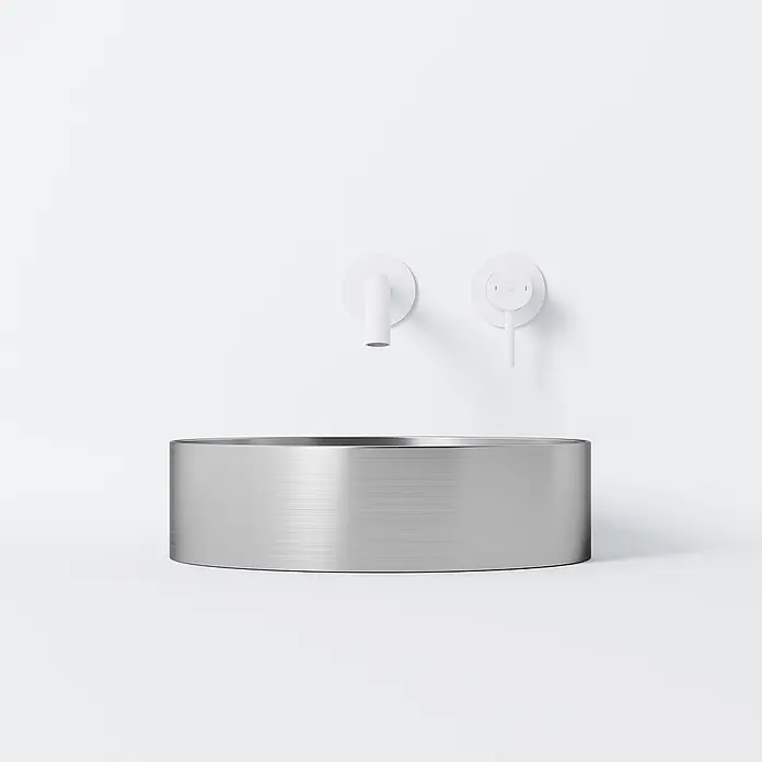 Vola Waschtisch -  - Rundes Waschbecken aus gebürstetem Metall mit weißer Wandarmatur und Bedienknopf.