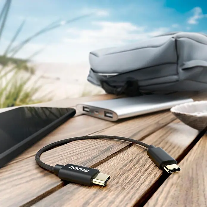 Hama USB-Kabel 00201604 USB-C - USB-C 0 Nylon 20 cm - Schwarz - Schwarzes Hama USB-C auf USB-C Kabel mit goldfarbenen Anschlüssen auf Holztisch, zum Laden von Mobilgeräten unterwegs.
