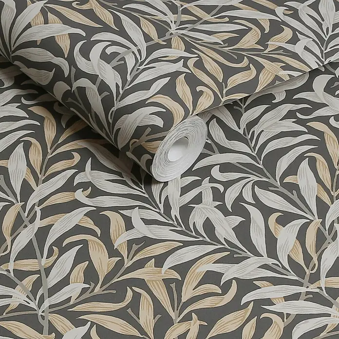 William Morris At Home Vliestapete Weidenzweig - Grau, Floral, 1.000 x 52 cm - Tapetenrolle mit dunkelgrauem Grund und einem Muster aus weißen und beigen Blättern.