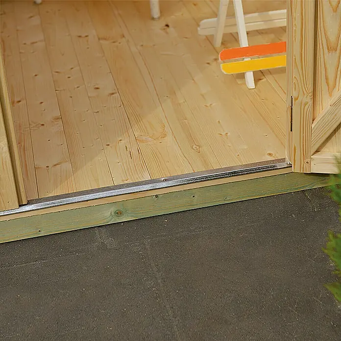 Kiehnholz Gartenhaus Eco-Lounge - Außenmaß inkl. Dachüberstand (B x T): 454 x 230 cm, Holz, Natur - Nahaufnahme der Türschwelle eines Holzhauses, die den Übergang zum Außenbereich zeigt. Die Schwelle ist mit einer Metallschiene verstärkt.
