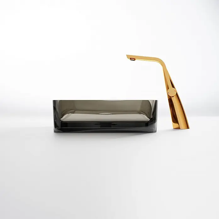 Vola Waschtisch - 0 x 0 cm - Goldfarbener Wasserhahn mit einem dunkelgrauen, durchscheinenden, rechteckigen Waschbecken.
