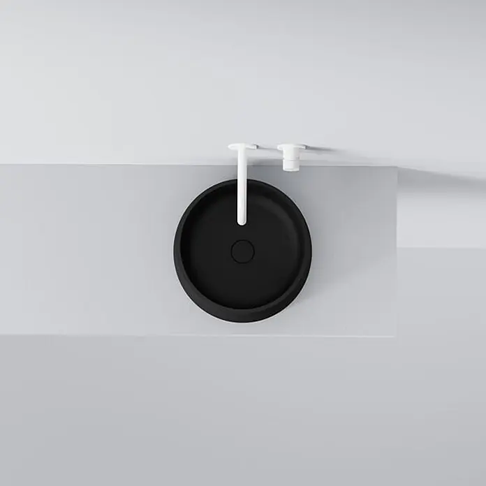 Vola Waschtisch - 0 x 0 cm - Schwarzes rundes Aufsatzwaschbecken mit weißem Wandhahn und weißem Ablaufstöpsel.