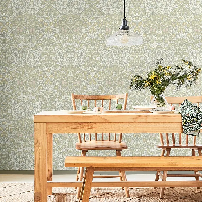William Morris At Home Vliestapete Vliestapete Schlehdorn - Salbeigrün, Floral, 10 x 0,52 m - Grüne Tapete mit dichtem, symmetrischem Muster aus weißen, gelben und rosa Blumen und Blättern an einer Esszimmerwand.