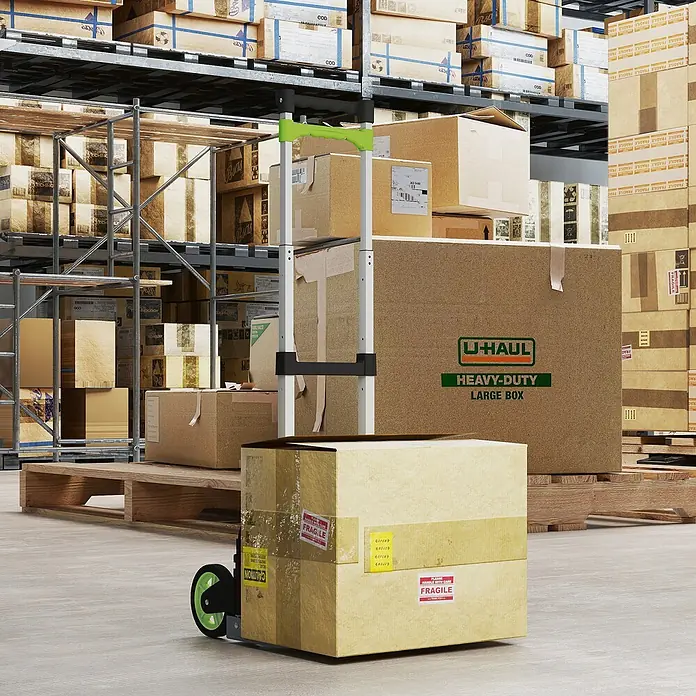 Homcom Sackkarre -  - Eine silberne Sackkarre mit grünem Griff und grünen Rädern transportiert einen Karton mit „fragile“-Etiketten in einem Lager.
