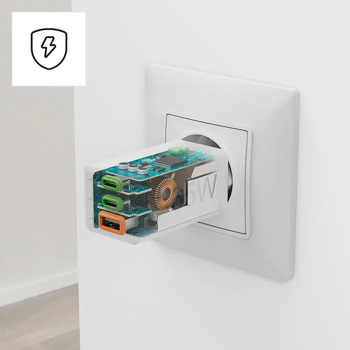 Hama Schnellladegerät 00201996 GaN 2x USB-C 1x USB-A Mini PD 65 W - Weiß - Transparenter USB-Ladeadapter mit sichtbarer Innenschaltung, drei Anschlüssen (zwei grün, einer orange) und "65W"-Beschriftung, in eine weiße Steckdose gesteckt.