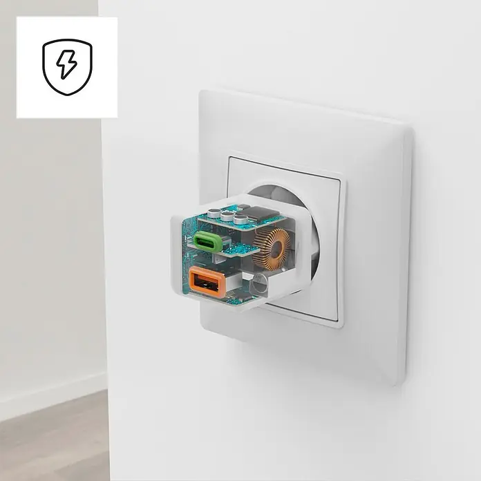Hama Schnellladegerät 00201992 1x USB-C 1x USB-A Mini PD 30 W - Weiß - Transparentes weißes Wandladegerät mit sichtbaren Schaltkreisen, orangefarbenen und grünen USB-Anschlüssen, in einer weißen Steckdose.