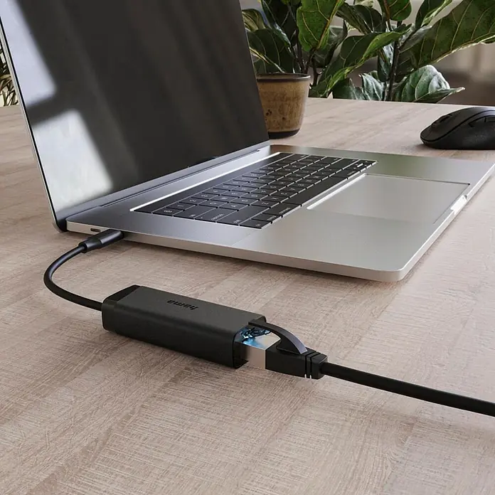 Hama Netzkabel USB 2.0 1x USB-C - 1x RJ45-Buchse - Schwarz - Schwarzer USB-C zu Ethernet Adapter, an silbernes Laptop und Ethernet-Kabel auf Holzschreibtisch angeschlossen.