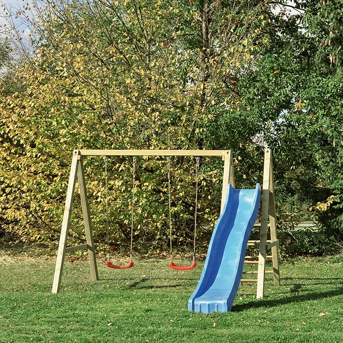 Schaukel Ronja - 315 x 167 cm - Kinderspielplatz mit Schaukel und Rutsche auf einer grünen Wiese, umgeben von Bäumen. Ideal für Spaß im Freien.