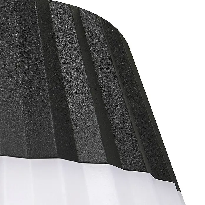 Lindby Erdspießleuchte Ameline - 77,2 cm - Nahaufnahme eines Produkts mit einem schwarzen, strukturierten, gerippten Oberteil und einem glatten weißen Unterteil, wahrscheinlich Teil einer modernen Leuchte.