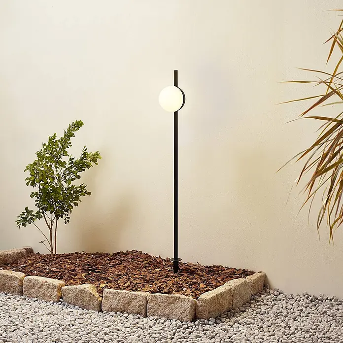 Lindby Erdspießleuchte Darleen -  - Elegante schwarze Gartenleuchte mit kugelförmiger weißer Lampe für stilvolle Außenbeleuchtung.