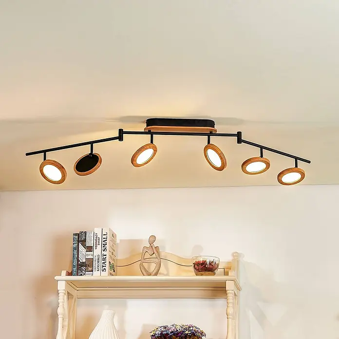Lindby Deckenstrahler Manel - L x B x H: 152 x 13 x 25 cm, Holz hell, Holz hell - Sechsflammiger Deckenstrahler mit schwarzem Metallrahmen und Naturholz-Akzenten, beleuchtet einen Raum von oben.