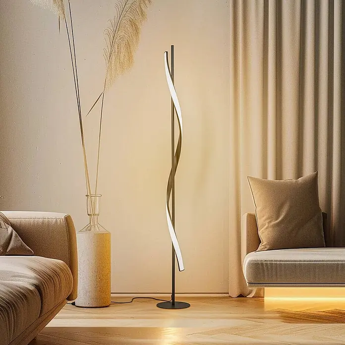 Lindby Stehleuchte Munja - Höhe: 150 cm, schwarz, schwarz - Eine moderne schwarze Stehlampe mit weißem leuchtendem LED-Spiralband steht auf einem Holzfußboden in einem gemütlichen Wohnzimmer.