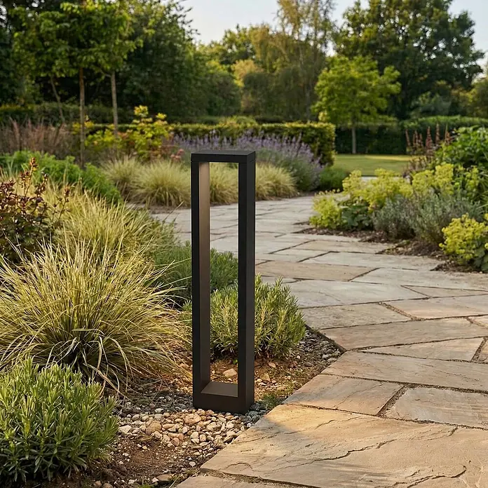 Lucande LED Wegeleuchte anthrazit Sockelleuchte 60 cm Gartenlampe Aluminium -  - Schwarze, rechteckige Außenleuchte beleuchtet einen Gartenweg mit Pflanzen.